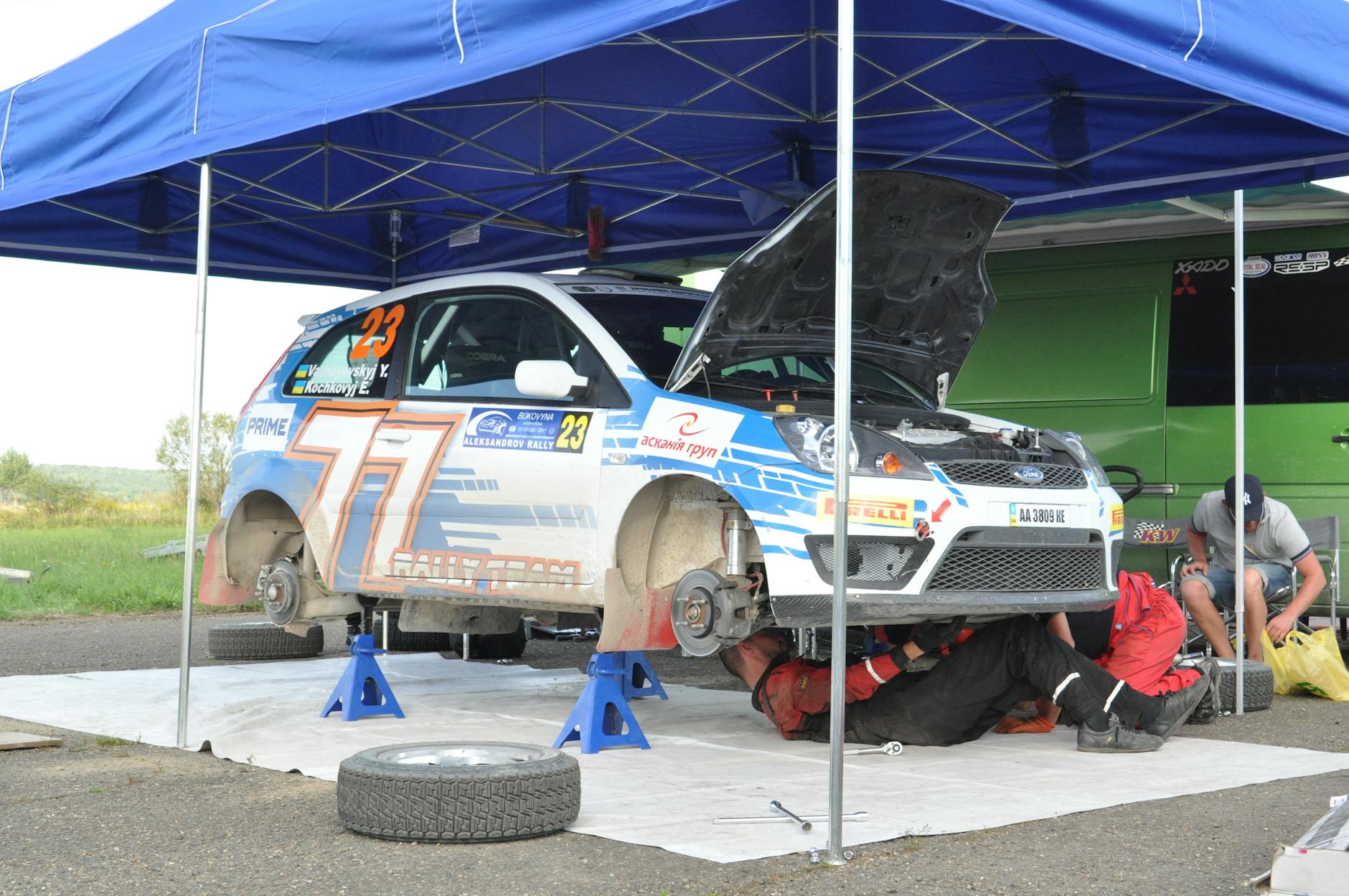 Mechanicy przygotowują rajdowego Cadillaca do startu pod namiotem