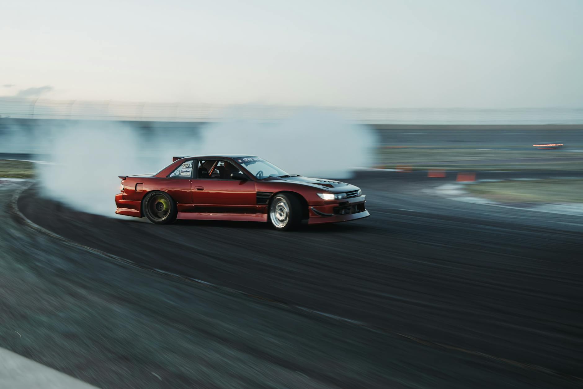 Czerwony Nissan w efektownym drifcie na torze wyścigowym w Kolorado