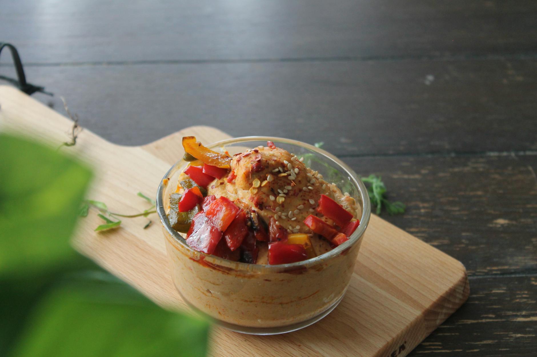 Miska hummusu z pieczonymi warzywami na drewnianej desce