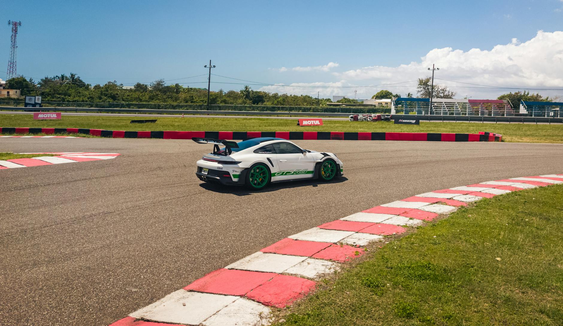 Sportowy samochód pokonuje zakręt toru w słoneczny dzień