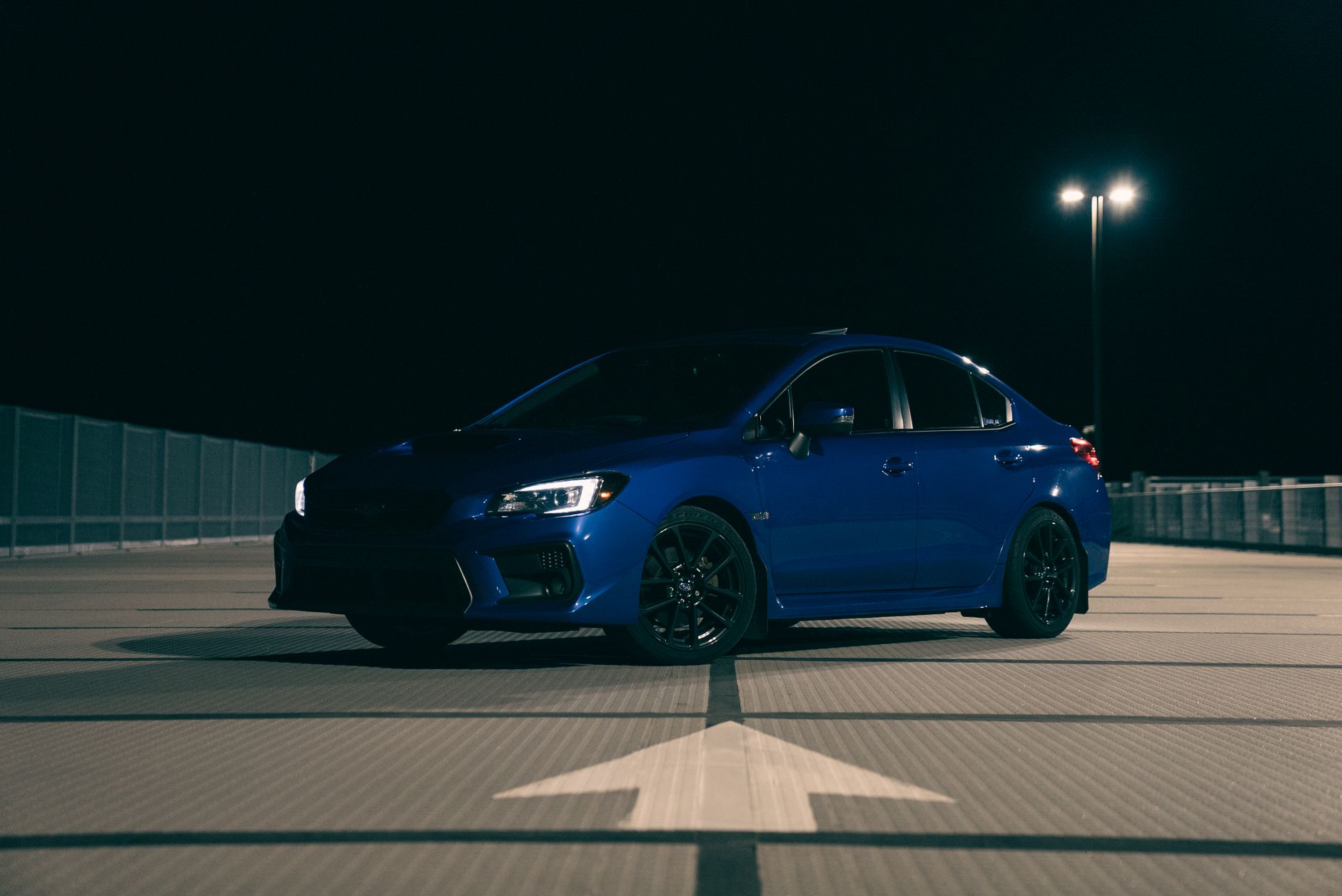 Niebieski Ford Fiesta nocą na pustym parkingu w świetle latarni