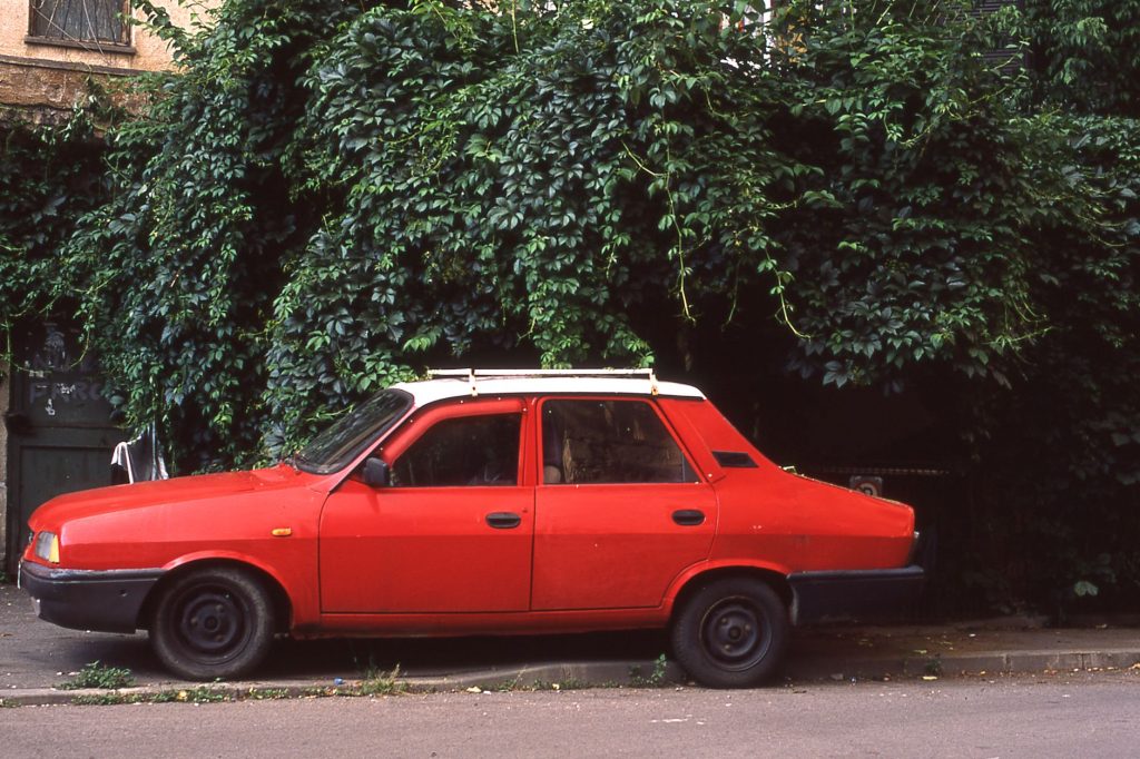 Czerwona Dacia 1310 zaparkowana przy ulicy w Bukareszcie