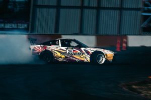 Samochód Mercedes-Benz w drifcie na torze, za nim kłęby dymu